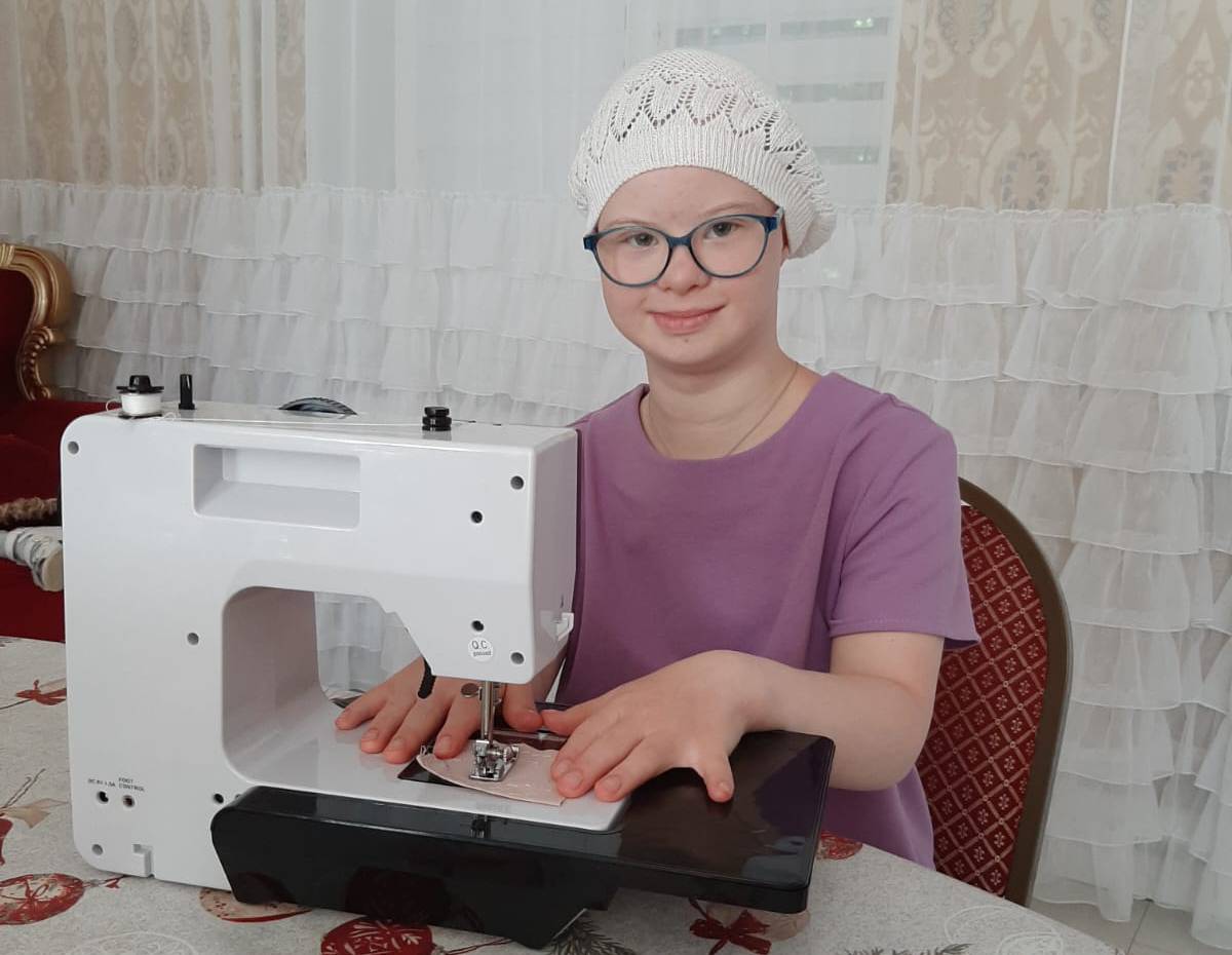 Девочка Юля шьёт на швейной машинке