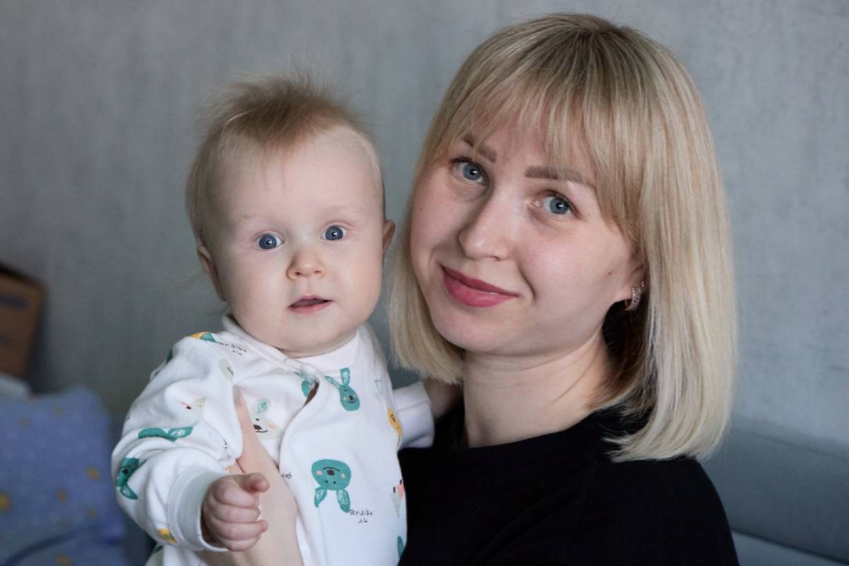 Женщина держит младенца