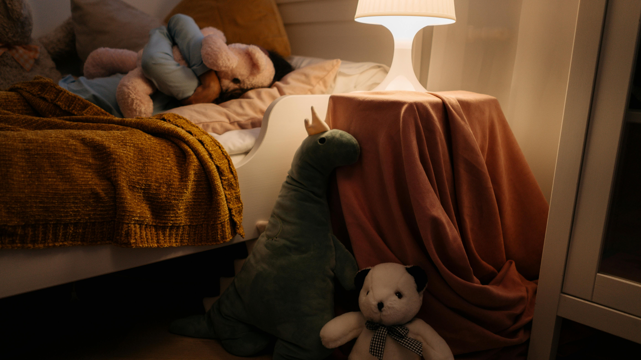 Детская кровать с тумбой и включенным ночником на ней