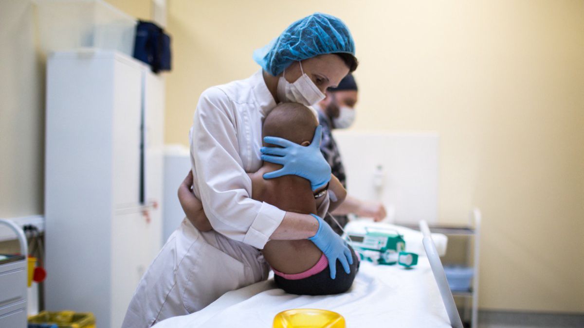 Доктор обнимает маленького пациента