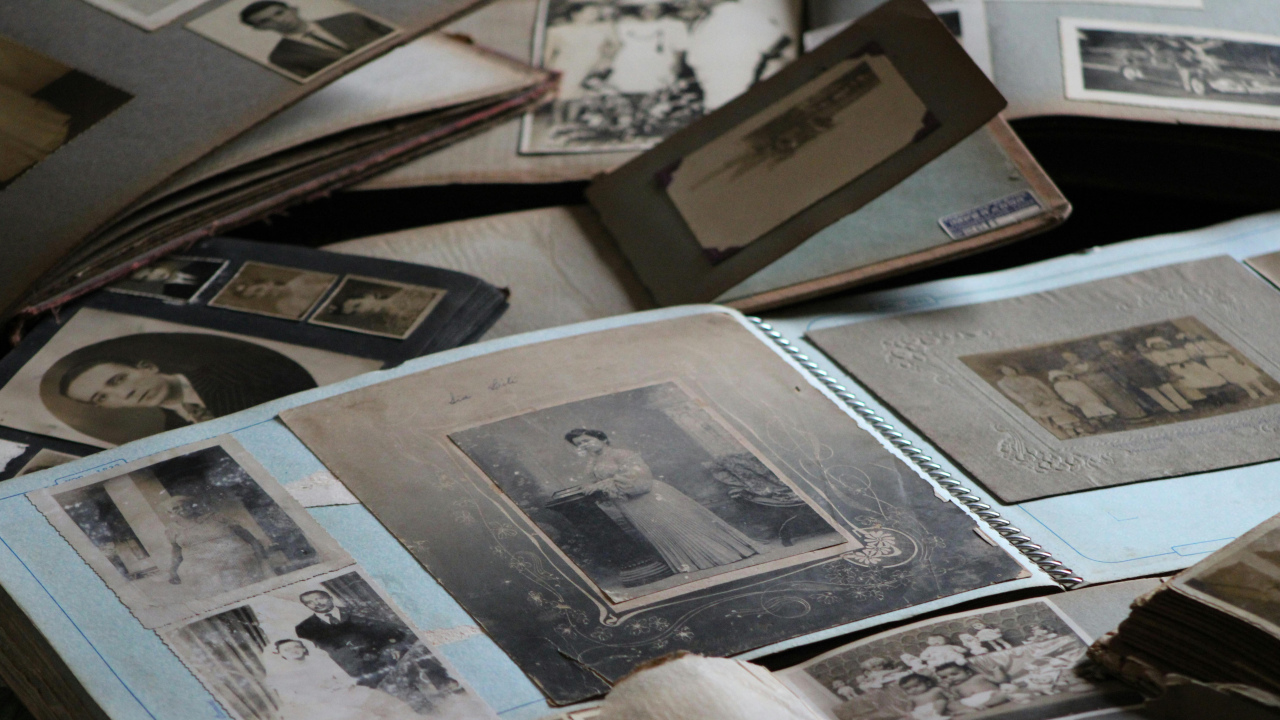 Старые, черно-белые фотографии, разложенные на столе