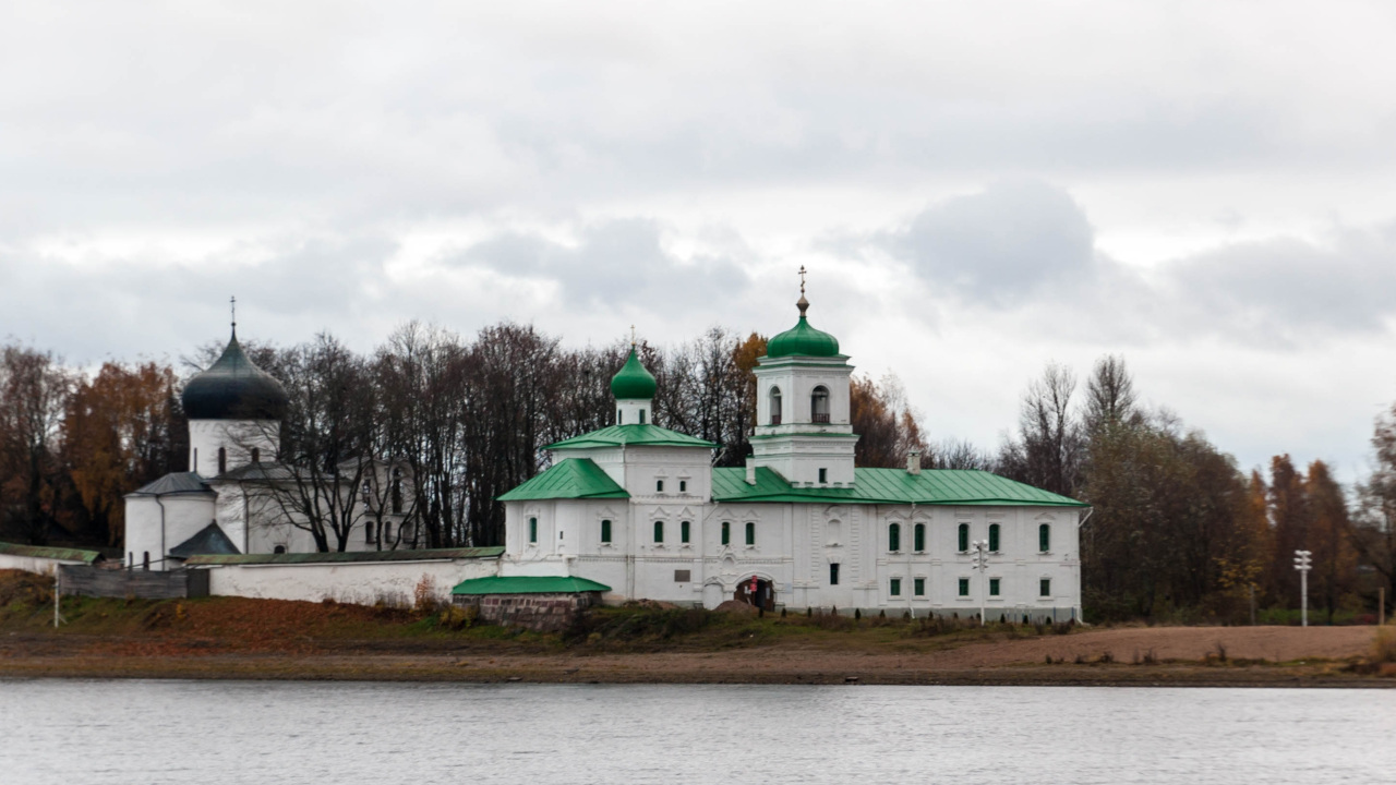 Белокаменный храм с зелёными куполами: стоит на берегу водоёма
