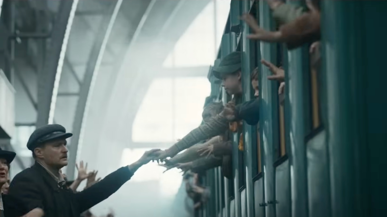 Дети тянут руки из окон поезда, прощаясь с родными