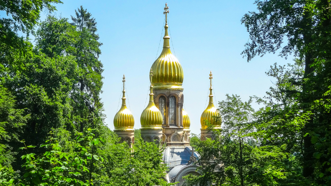 Золотые купола храма виднеются сквозь листву